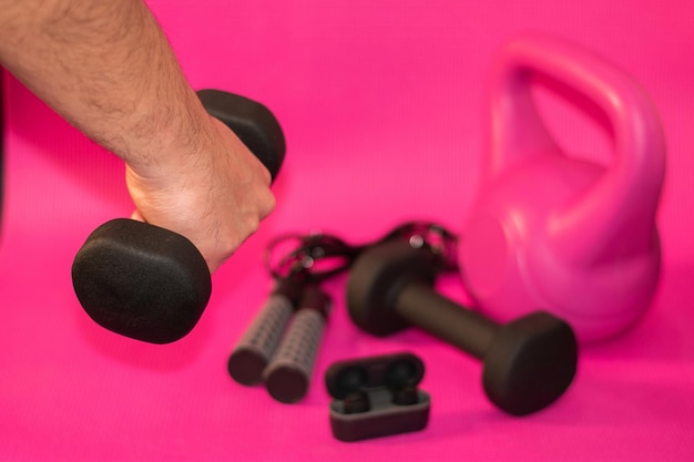 A man lifting weights on a pink background