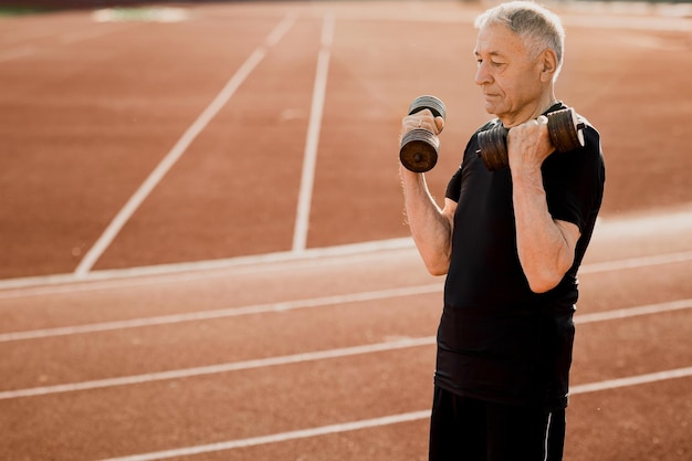 A man lifting weights on a track