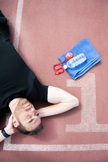 Man liggend op de atletiekbaan