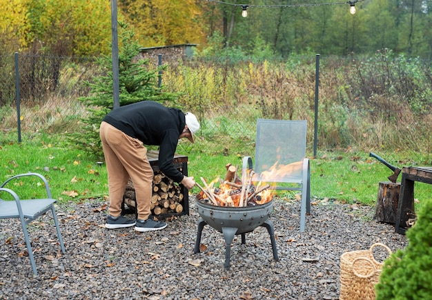 A man lights a barbecue in nature