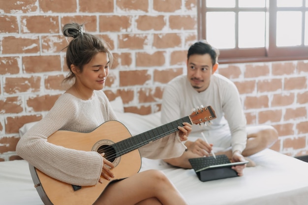 Man listening to his girlfriend playing guitar on a good hobby weekend