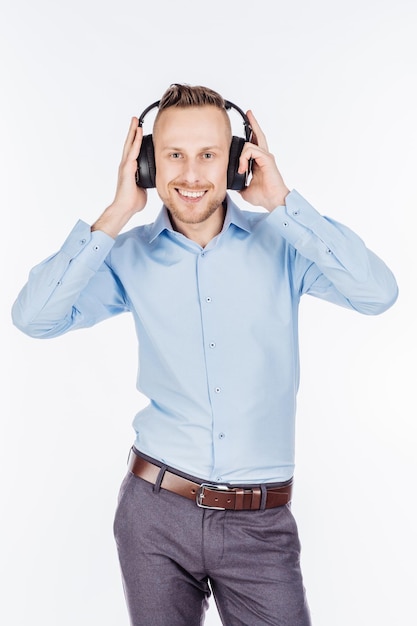 Мужчина слушает музыку в наушниках, студия снята на белом фоне