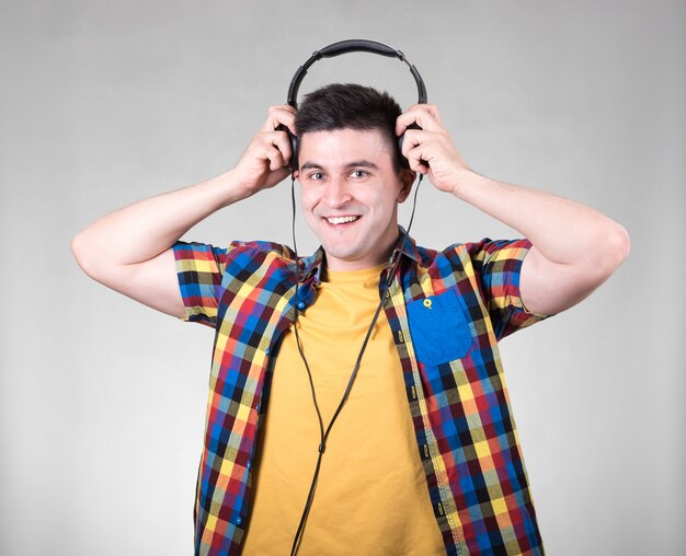 Man listening to music isolated on grey wall