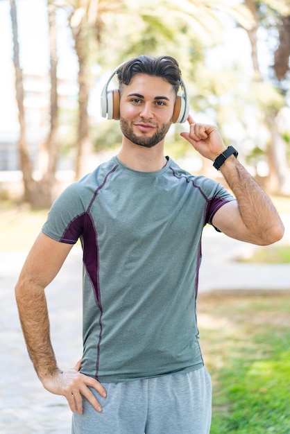 Мужчина слушает музыку в наушниках на улице