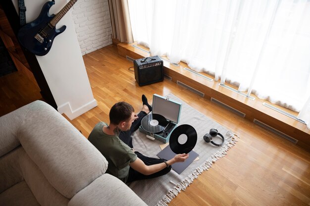 写真 ビニールレコードから音楽を聴いている男