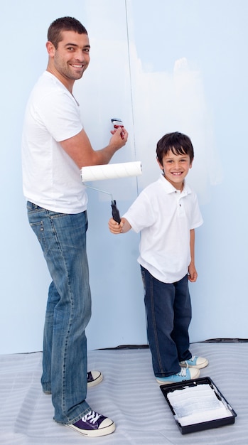 Man and little boy painting a wall