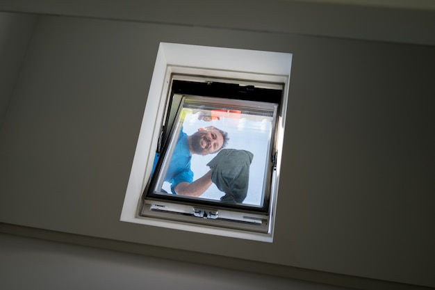 Man on loft window cleaning