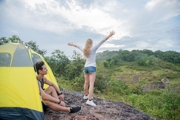 男はガールフレンドを見て、美しい山々の中でリラックスした気分になります