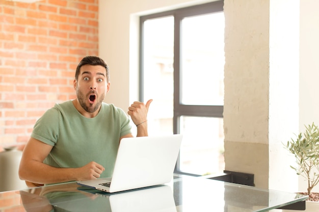 man  looking astonished in disbelief, pointing at object on the side and saying wow, unbelievable