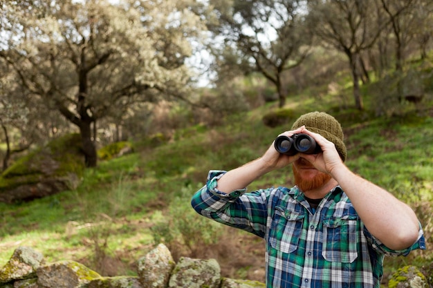 Foto uomo che guarda lontano nella foresta