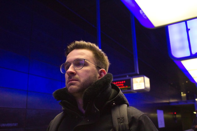 Man looking away at illuminated subway station