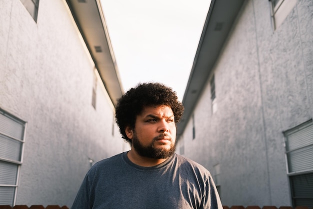 Photo man looking away while standing against wall