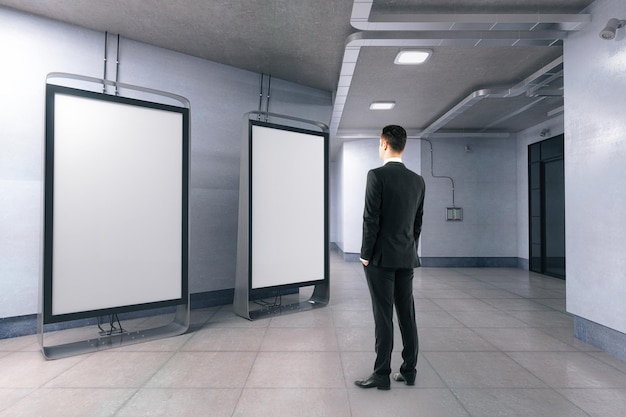 Man looking at blank billboards