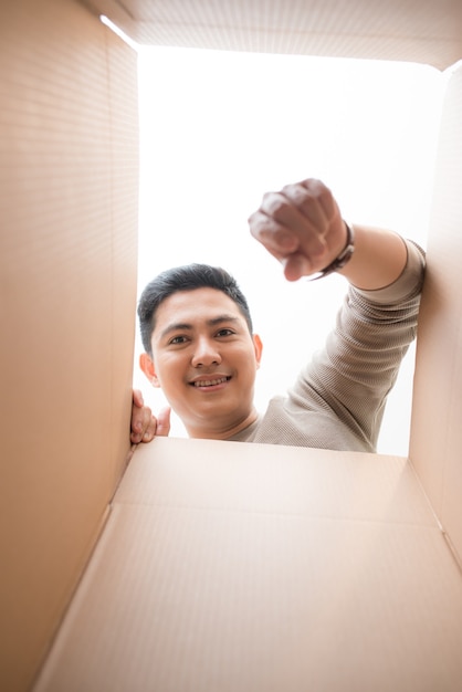 Man looking down at camera through cardboard box