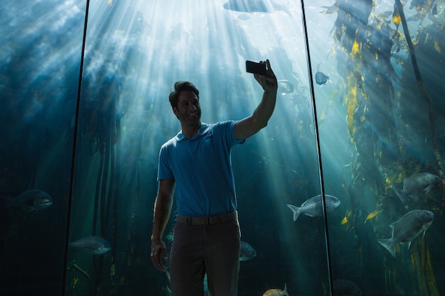 Foto uomo che guarda il serbatoio di pesce