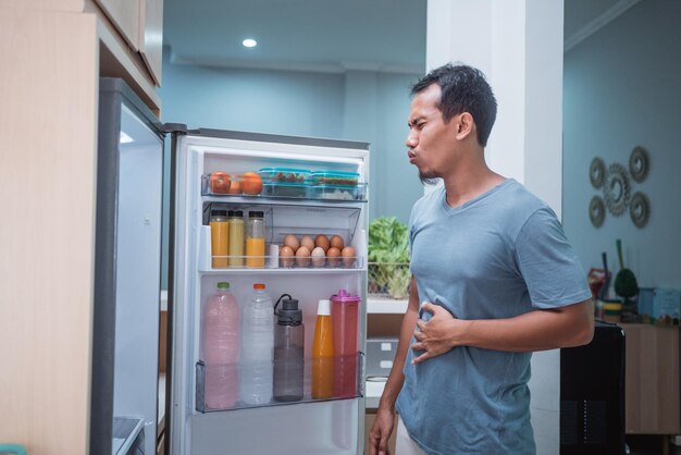 家で食べ物を見ている男