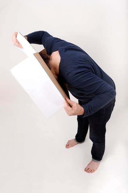 man looking into a white box