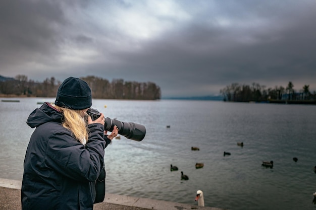 Man looking at lake against cloudy sky