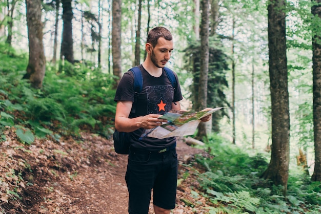 Man looking at the map while hiking in the forest