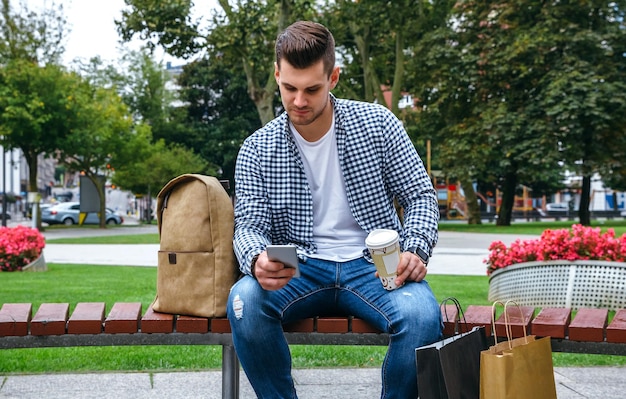 Man looking mobile sitting on a bench