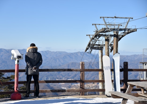 桟橋から冬に山を見ている男