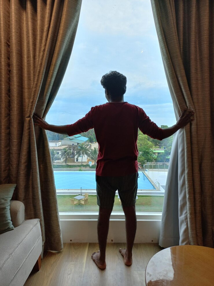 फोटो man looking out side the view from room