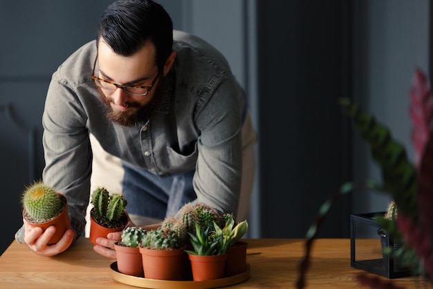 テーブルの上の植物を見ている男性