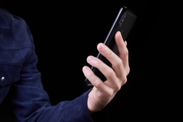 Man looking at smartphone screen on dark background