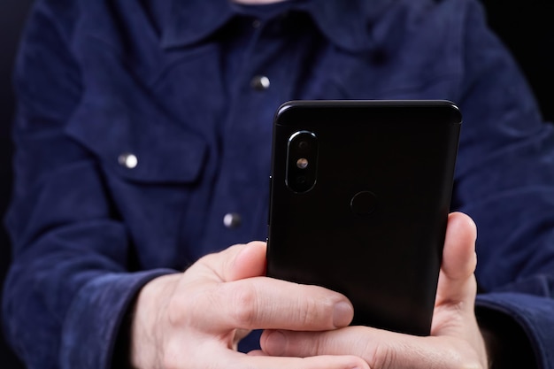 Man looking at smartphone screen on dark background