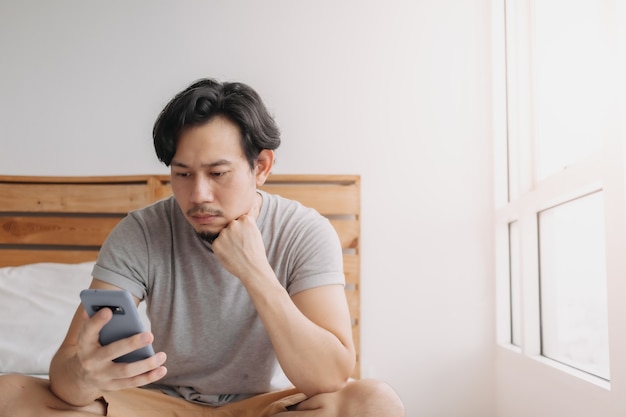 Man looking at smartphone with serious face