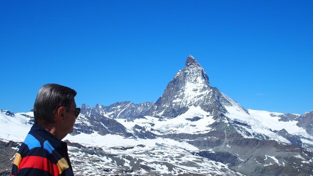 Man looking at snowcapped mountain