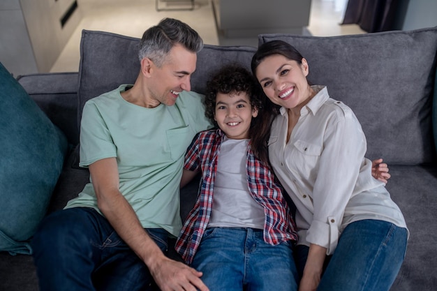 Man looking at son and woman smiling at camera