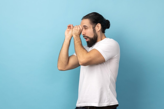 Foto uomo che guarda attraverso il gesto monoculare ed esprime sorpresa zoomando la visione esplorando la distanza