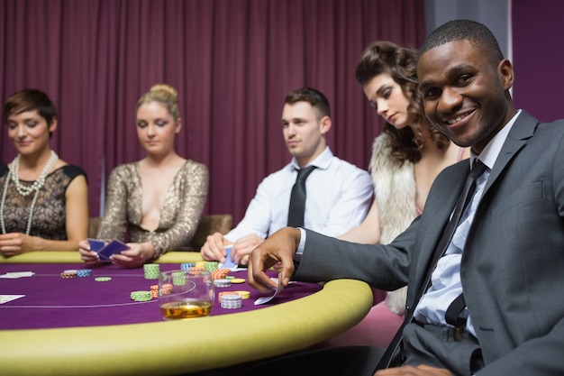 Man looking up from poker game and smiling