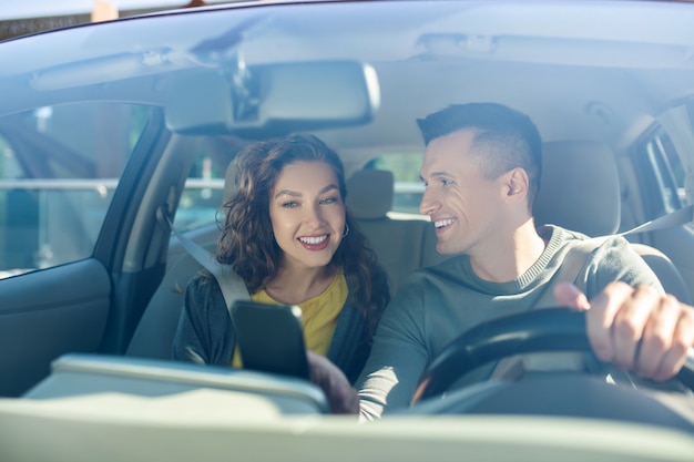 Man looking at a woman, both sitting in a car