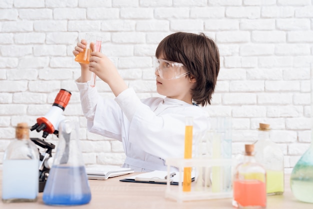 Man looks at the chemical reactions in the flask 