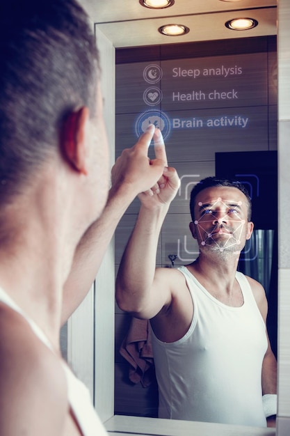 Foto un uomo guarda in uno specchio intelligente e seleziona i parametri di salute dopo essersi svegliato al mattino
