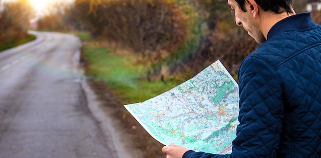 男は道路上の地図を見る セレクティブ フォーカス