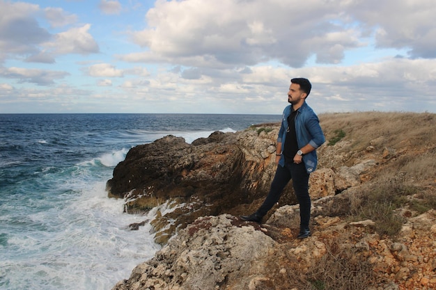 Man looks out to sea from coastal area