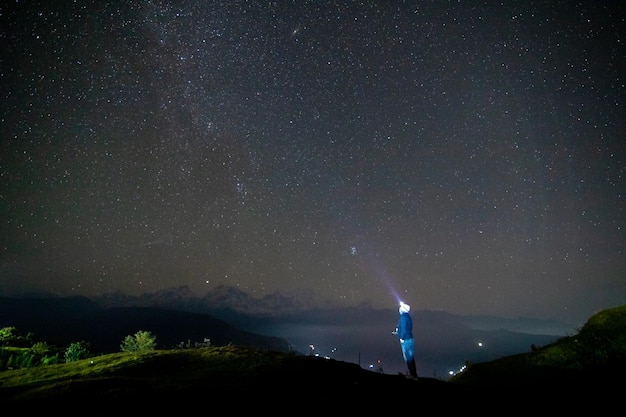 A man looks up at the stars in the sky.