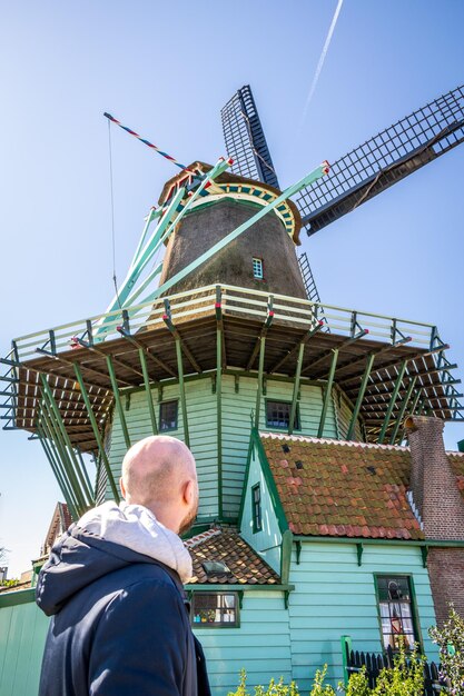 A man looks at a windmill in the netherlands