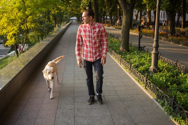 Man loopt met zijn hond in een park