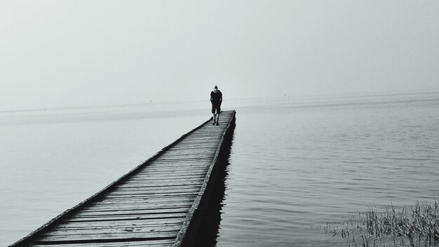 Foto man loopt op de pier.