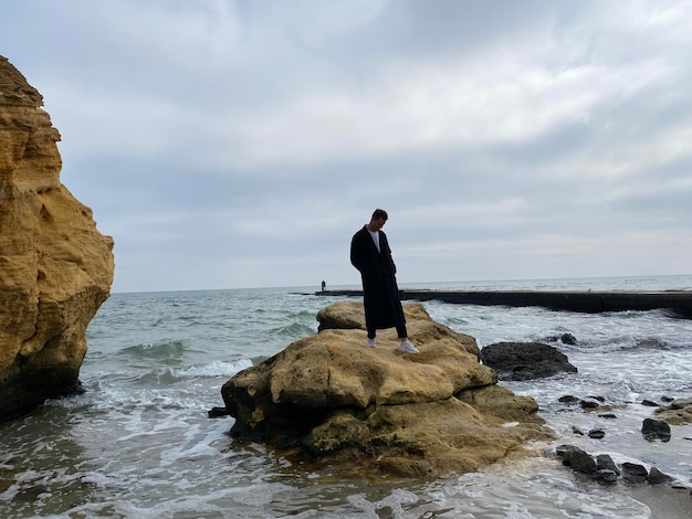 Man lopen op stenen in het water op zee strand