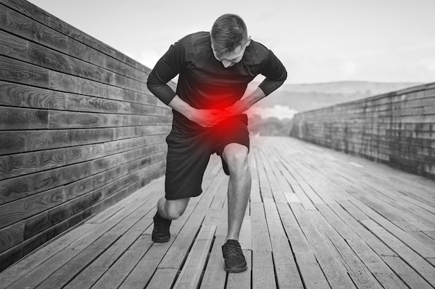 Foto man loper met steek in de buik of krampen atleet die lijdt aan pijn in de zij na het hardlopen