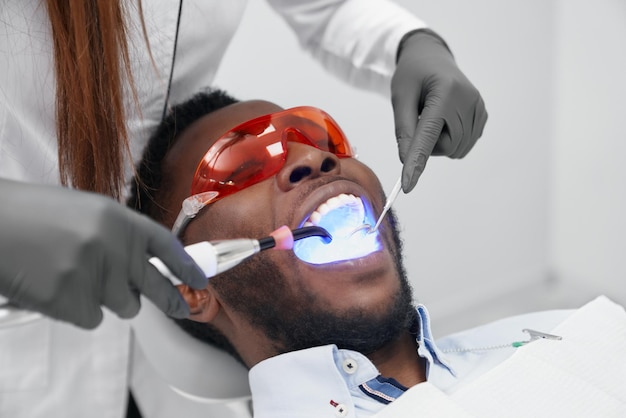 Man lying on dentist chair in protective glasses in clinic