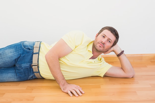 Foto uomo sdraiato sul pavimento a casa