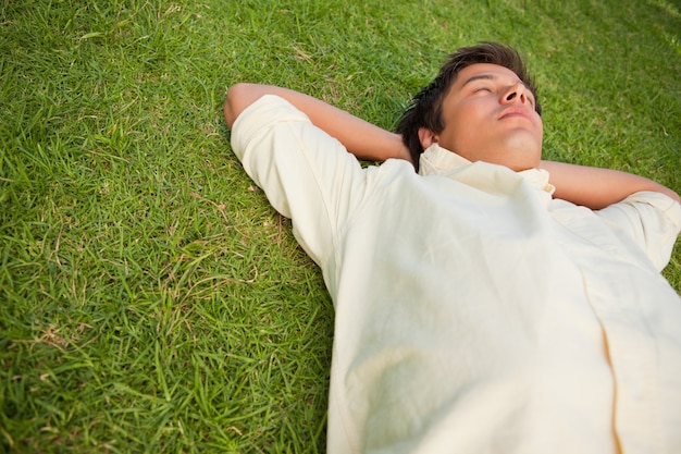 사진 그의 눈을 감고 잔디에 누워있는 남자