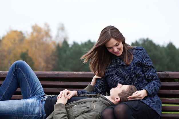 Man lying in lap of young woman