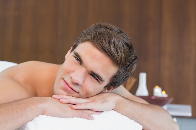 Man lying on massage table at spa center